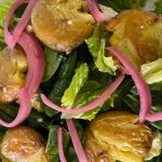 Recipe: This green salad is garnished with smashed potatoes warm from the oven