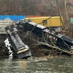 Train derailment leaves cars on riverbank or in water; no injuries, hazardous materials reported