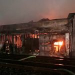 Huge Oakland lumber yard blaze smolders as firefighters probe cause